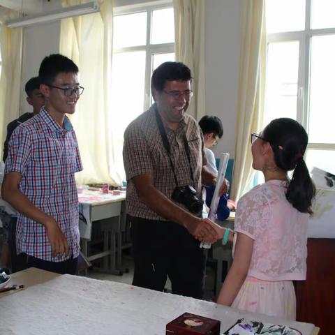 格尔木昆仑世界地质公园验收活动中的小插曲《外国专家老师和小学生探讨中国画》